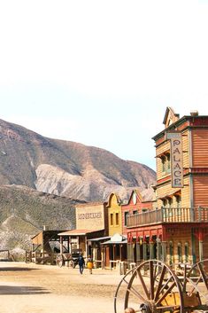 an old western town with mountains in the background