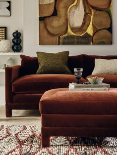 a living room filled with furniture and a painting on the wall above it's coffee table