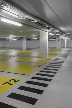 an empty parking garage with yellow and black markings on the floor is pictured in this image