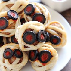 small pastries with red and black toppings on a white plate