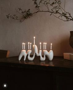 a group of white candles sitting on top of a wooden table