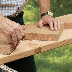 a man cutting wood with a knife on top of a piece of wood that has been cut in half