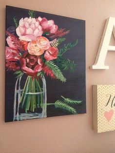 flowers in a vase are displayed on the wall next to a letter and an acrylic sign