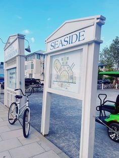 a bike parked next to a sign that says seaside