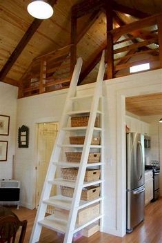 a living room filled with lots of furniture and a white ladder on the wall above it