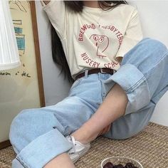 a woman sitting on the floor next to a bowl of chocolate covered donut holes