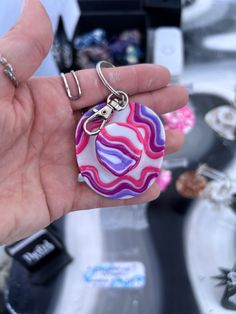 a hand holding a keychain that is shaped like a swirly pattern with the word love on it