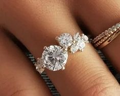 a woman's hand with two engagement rings on it