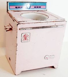 an old pink washing machine with a blue lid on it's front and side