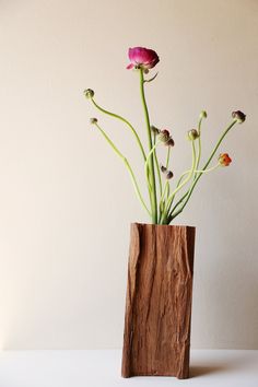 a wooden vase filled with flowers on top of a table