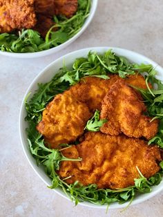 two white bowls filled with fried food on top of a marble countertop next to each other