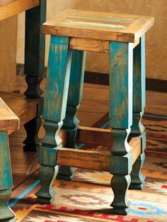 a wooden stool sitting on top of a colorful rug