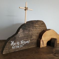 a wooden church with a cross on the top and another piece of wood below it