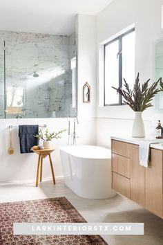 a white bath tub sitting under a bathroom mirror