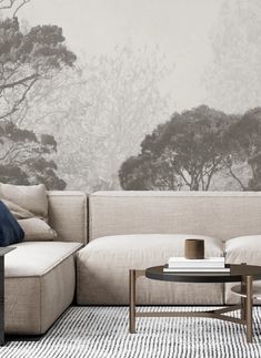 a living room with a sectional couch and coffee table in front of a mountain backdrop