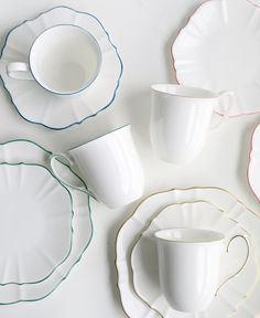 white dishes and cups are arranged on a table