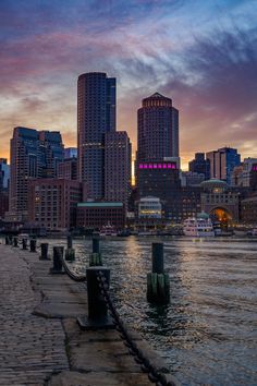 the city skyline is lit up at night as it sits on the water's edge