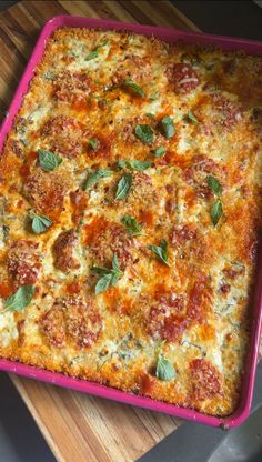 a casserole dish with cheese, sauce and basil leaves on the top is ready to be eaten