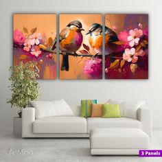 three birds sitting on a branch with pink flowers in the foreground and an orange background