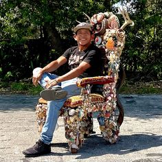 a man sitting on top of a colorfully decorated chair with an animal like seat