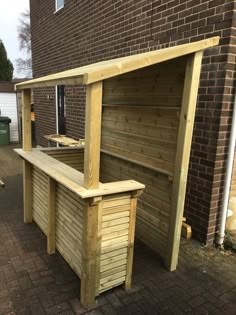 a wooden bench sitting next to a brick building