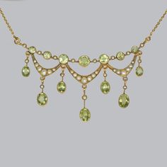 Stunning peridot & seed pearl necklace by Birks This rare Edwardian necklace is by the famous Canadian jewellers Birks Beautifully designed and hand crafted in 14 ct gold this fringe necklace is set with alternating peridots and seed pearls, with seed pearl swags below and suspending further seed pearl and oval peridots. The assembler hangs from an integral trace link chain with spring clasp The reverse is signed BIRKS 14ct. It dates to around 1910 This elegant pendant looks fabulous when worn T Swag Necklace, Pearl Jewelery, Edwardian Necklace, Art Nouveau Necklaces, Edwardian Jewelry, Big Diamond, Fringe Necklace, Elegant Pendant, Jewel Box