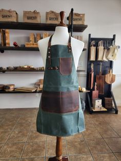 a mannequin wearing an apron made out of canvas and leather straps, in a shop