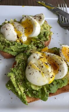 avocado toast topped with eggs on a white plate