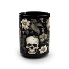 a black coffee mug with a skull and flowers on it