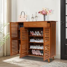 a wooden shoe rack with shoes on it and a vase filled with flowers next to it