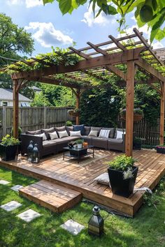 an outdoor living area with couches, tables and potted plants on the deck