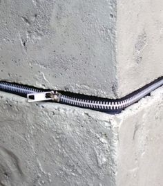 a black zipper is attached to a concrete block