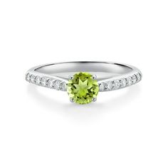 a ring with a green stone and white diamonds on the sides, set in 18k white gold