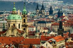 the city is full of tall buildings with green domes and spires on each side