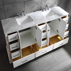 two sinks are shown with open drawers in this bathroom sink area, and the countertop is made of white marble