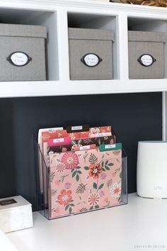 a white desk topped with drawers and bins filled with boxes on top of it