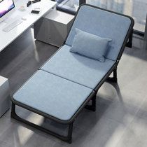 a blue chaise lounge chair sitting in front of a computer desk with a monitor on it