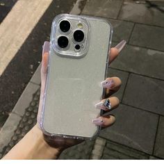 a woman holding up her phone case with clear glitter on the front and back cover