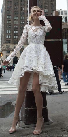 a woman is posing on the street with her legs crossed and wearing a white dress