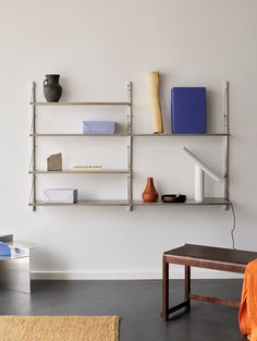 a white wall with shelves and vases on it