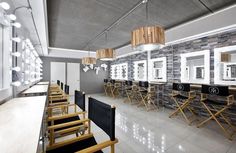 an empty restaurant with wooden chairs and lights hanging from the ceiling, along with black and white tiles on the walls