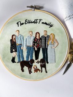 an embroidered family portrait on a white background with scissors and thread in the foreground