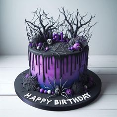 a purple and black birthday cake with spooky decorations