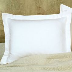 two white pillows sitting on top of a bed