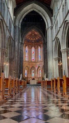 the inside of a large church with pews and stained glass windows on both sides