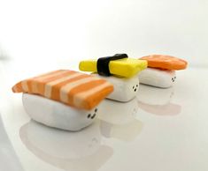 three sushi shaped like cats sitting on top of a white table next to each other