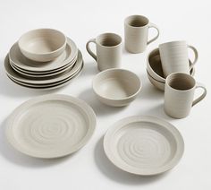 a table topped with white dishes and cups