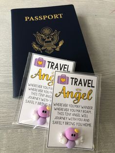 a passport and an angel brooch sitting on top of a table next to each other