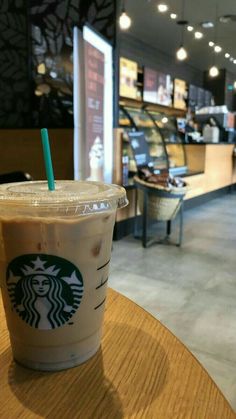 a starbucks drink sitting on top of a wooden table