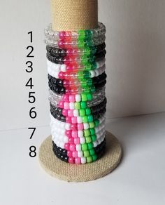 a stack of bracelets sitting on top of a wooden stand